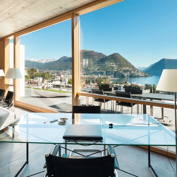 Modern office workspace with panoramic mountain lake view
